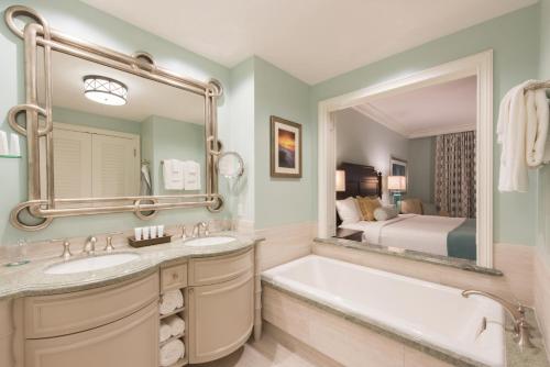 - Baño con 2 lavabos, bañera y cama en Henderson Beach Resort, en Destin