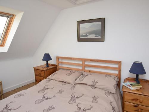 a bedroom with a bed and two lamps and a picture at 3 Bed in Isle Of North Uist oc-77239 in Sollas