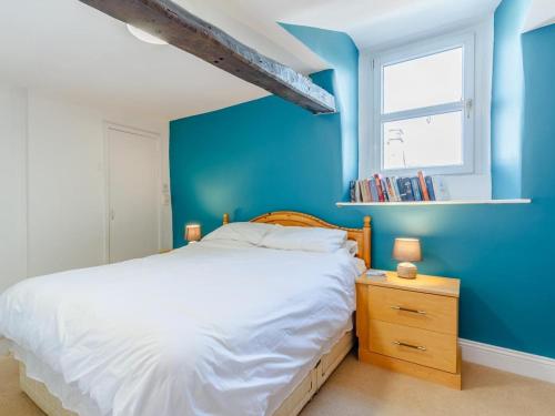 a blue bedroom with a bed and a window at 2 Bed in Kirkby Thore oc-78744 in Kirkby Thore
