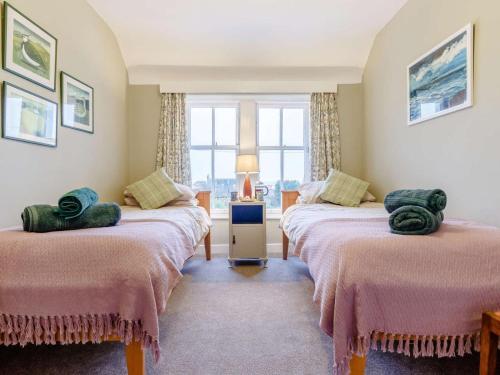 two beds in a room with a window at 2 Bed in Anstruther oc-ca006 in Crail