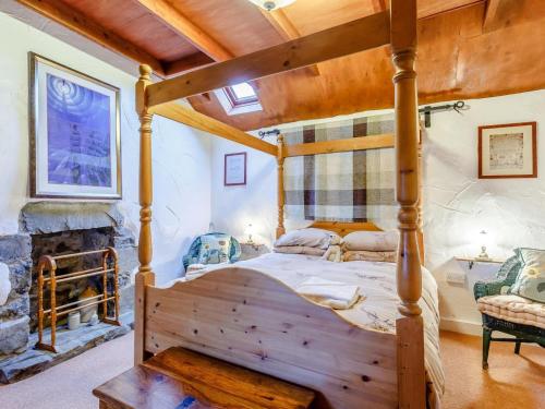 a bedroom with a wooden bed in a room with a fireplace at 1 Bed in Isle Of Skye oc-ca073 in Glendale