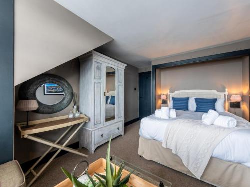 a bedroom with a large white bed and a mirror at 3 Bed in Stranraer oc-77308 in Portpatrick