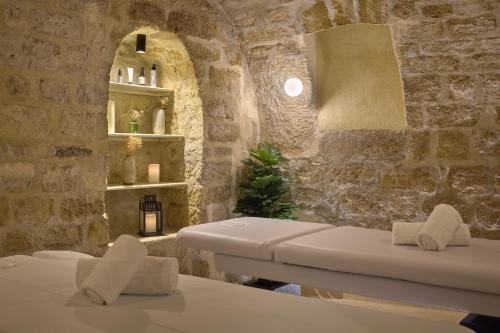 a room with two white chairs and a stone wall at Hôtel Joséphine & SPA by HappyCulture in Paris