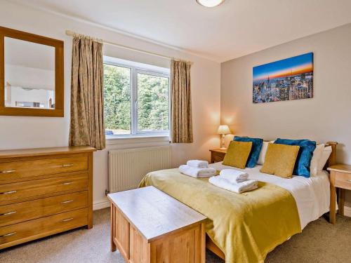 a bedroom with a bed and a dresser and window at 3 Bed in Penrith oc-85896 in Penruddock