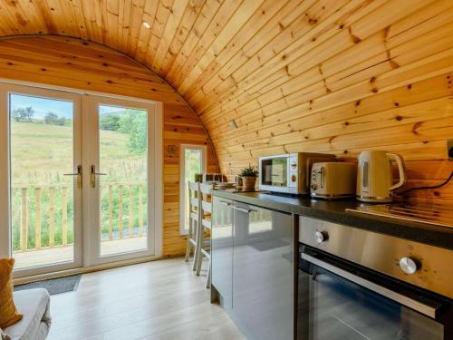 a kitchen with wooden walls and a large window at 1 Bed in Coniston oc-88961 in Coniston