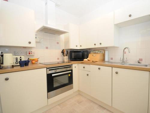 a white kitchen with white cabinets and a sink at 2 Bed in Fort Augustus oc-in637 in Fort Augustus