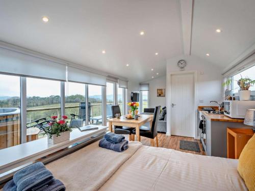 a bedroom with a bed and a kitchen with a table at 1 Bed in Dalry oc-91418 in Dalry