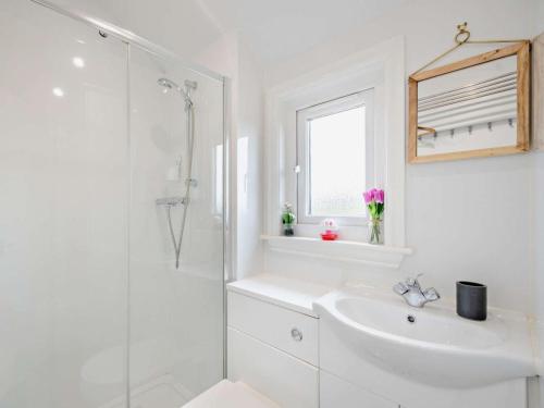 a white bathroom with a sink and a shower at 1 Bed in Dalry oc-91418 in Dalry