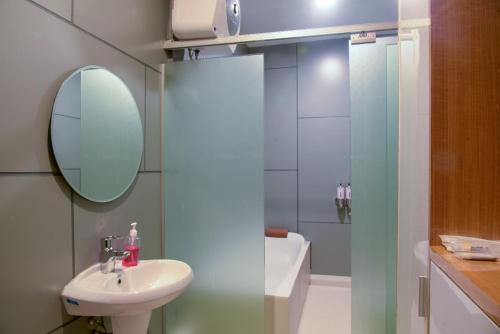 a bathroom with a sink and a mirror and a shower at Lembah Indah Malang in Gendogo