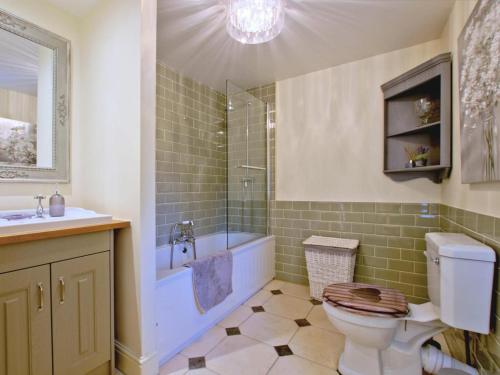 a bathroom with a toilet and a tub and a sink at 3 Bed in Middleham oc-78935 in Middleham