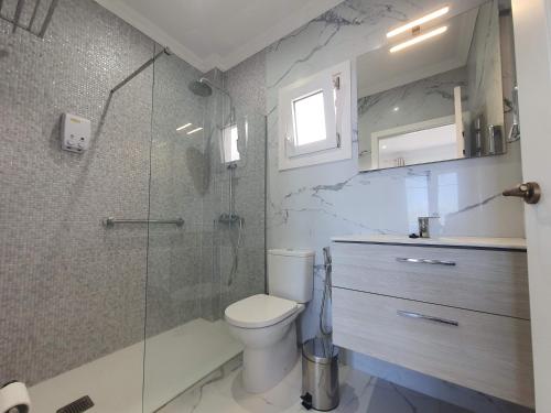 a bathroom with a toilet and a glass shower at Casa Sandra in Tazacorte