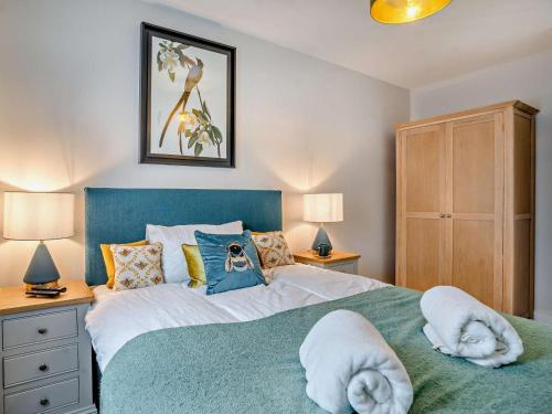 a bedroom with a large bed with towels on it at 3 Bed in Swansea oc-91720 in Killay