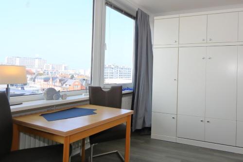 a room with a desk and a window and a table at Rüter 57 w in Westerland