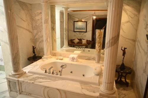 a bathroom with a tub and a large mirror at The Imperial, New Delhi in New Delhi