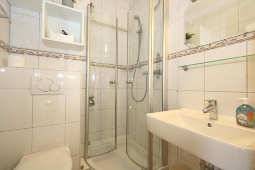 a bathroom with a shower and a toilet and a sink at Rüter 57 w in Westerland