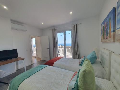 two beds in a bedroom with a view of the ocean at Casa Sandra in Tazacorte
