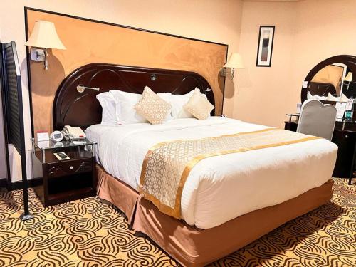 a hotel room with a large bed and a chair at Awaliv Hotel in Taif