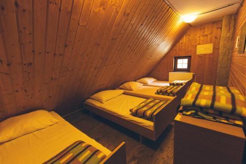 a room with three beds in a wooden cabin at Tamar Mountain hut in Rateče