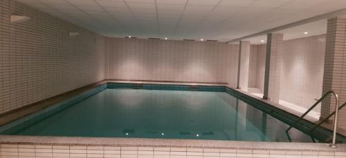 a large swimming pool in a room with a tile wall at Alte Teestube Alte Teestube 57 in Norderney