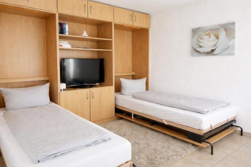 a small room with two beds and a tv at Alte Teestube Alte Teestube 14 in Norderney