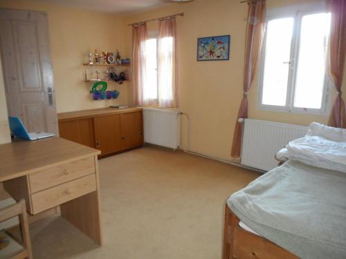 a bedroom with a desk and a bed and windows at Chata Pilka in Nové Hamry