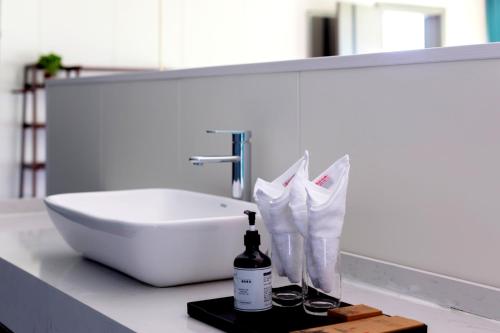a bathroom counter with a sink and a bottle of alcohol at Bor Manju Vacation guesthouse--Near the Ticket Gate--service in Chinese and English in Zhangjiajie