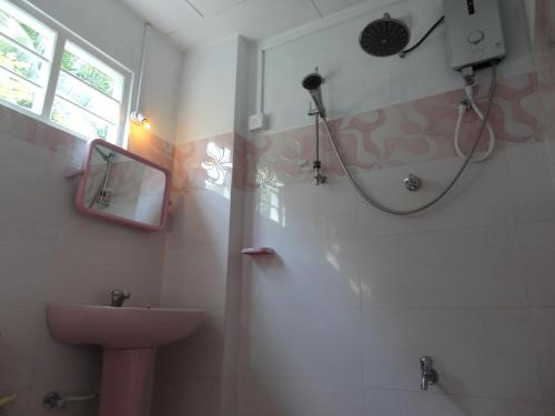 a bathroom with a sink and a shower with a mirror at Abha Villa in Galle