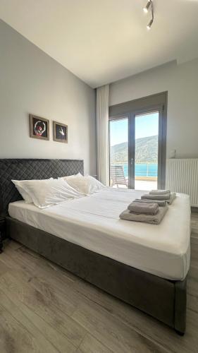 ein Schlafzimmer mit einem großen Bett und einem großen Fenster in der Unterkunft Ocean views in Plataria