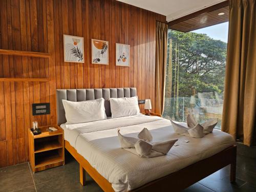 a bedroom with a large bed with a window at Hotel Navas Inn- Pure Veg, Kolhapur in Kolhapur