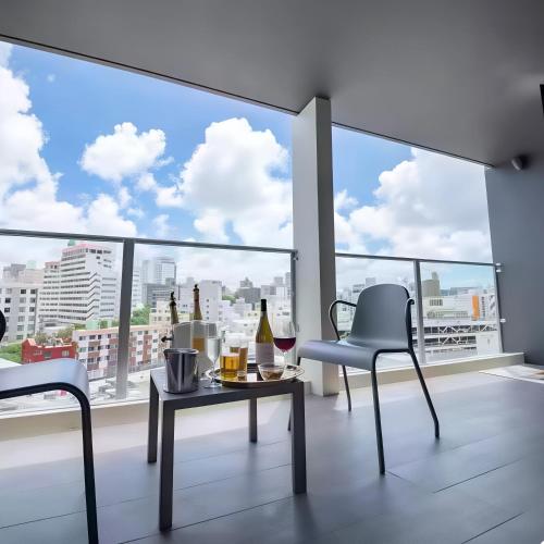 a living room with a table and chairs and a large window at HOTEL Viviana in Naha