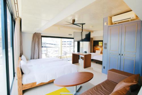 a bedroom with two beds and a table and a couch at HOTEL Viviana in Naha
