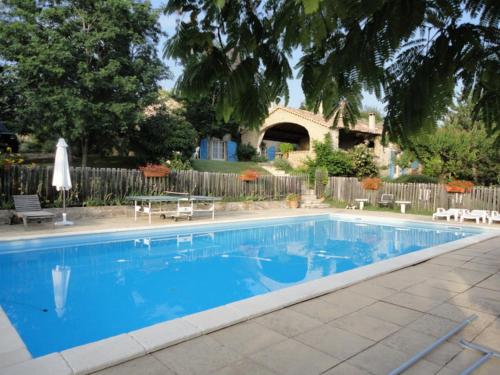 a swimming pool with a house in the background at Le Jas des Sagnières - Un Gite de Charme en Haute Provence in Sigoyer