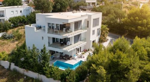 an aerial view of a white house with a swimming pool at Villa Berfami - Managed by Excelsior Villas in Podstrana