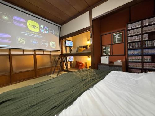 a room with a bed and a large screen at 一棟貸し宿 maicca2 in Numazu