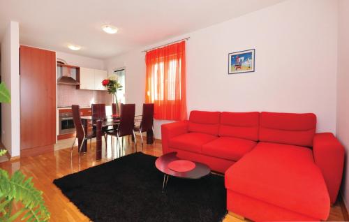 a living room with a red couch and a table at Apartments Beverly in Omiš