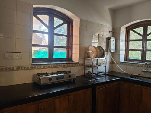 a kitchen with a stove and a sink and a window at The Coastal Villa Arpora in Parra