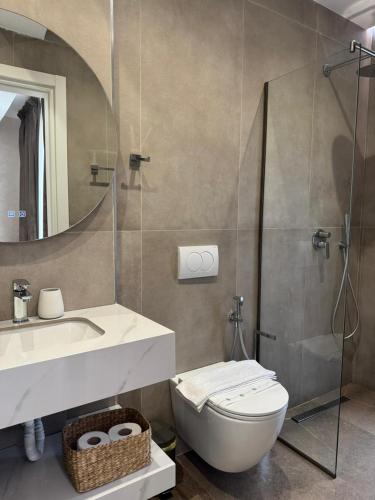 a bathroom with a toilet and a sink and a mirror at Hotel Veizi in Himare