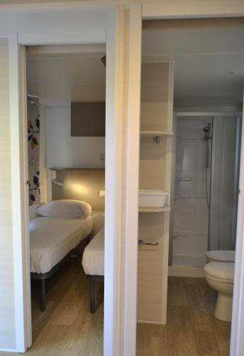 a bedroom with a bed and a bathroom with a toilet at Camping 4 Cerchi Ecogreen in Lido di Fermo