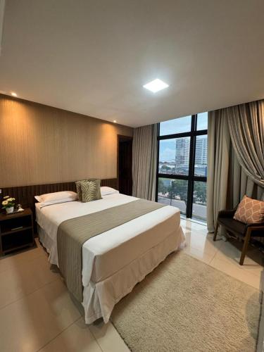 a bedroom with a large bed and a large window at Hotel Universal in Santarém
