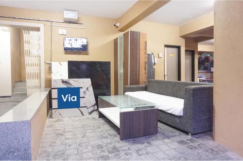 a living room with a couch and a table at Via Shree Haree Residency in Pune