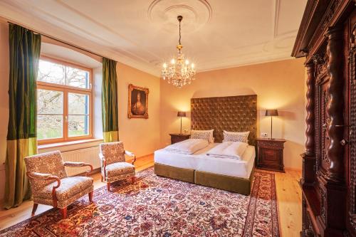 a bedroom with a bed and a chandelier at Schloss - Schenke Tunzenberg in Mengkofen