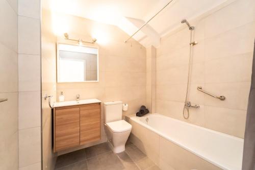 a bathroom with a toilet and a tub and a sink at Attic Duplex Apartment with 4 terraces & 5 min walk to Beach in Denia