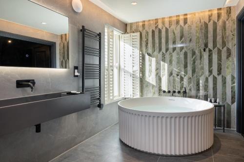 a bathroom with a large tub and a sink at Sanctuary Knocker in Durham