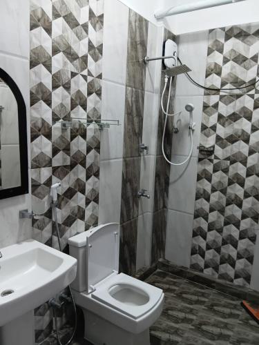 a bathroom with a toilet and a sink and a shower at Ocean waves in Trincomalee