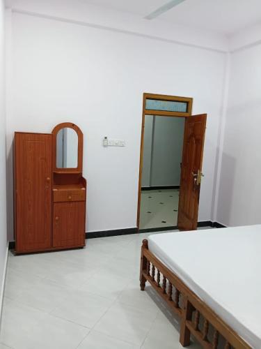 a bedroom with a bed and a mirror and a dresser at Ocean waves in Trincomalee