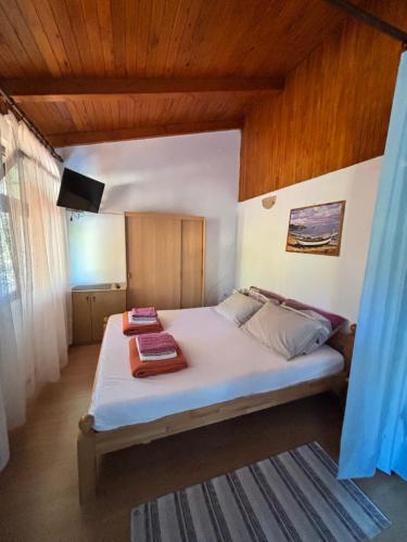 a bedroom with a bed with two towels on it at Apartman Mira in Karlobag