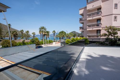 a glass roof on a building with palm trees at Beach Suites İçmeler Marmaris in İçmeler
