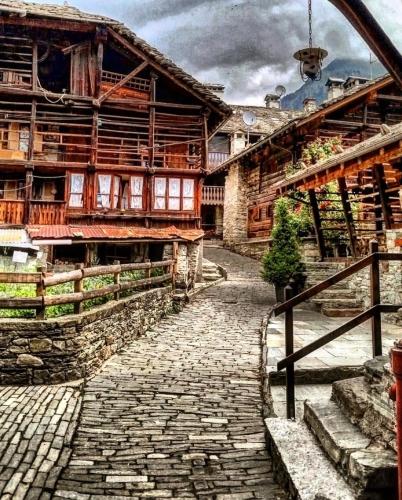 a stone path in front of a wooden building at Baita Genepy - Charme Alpino in Pietra in Alagna Valsesia