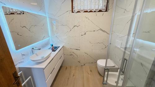 a white bathroom with a sink and a shower at Lake Garda Apartment - Panorama in Brenzone sul Garda