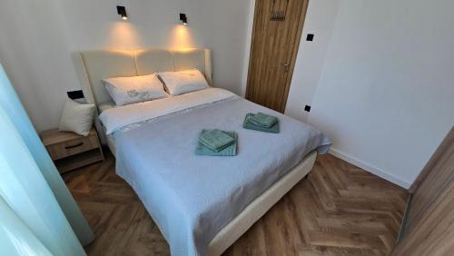 a bedroom with a bed with two towels on it at Sea Nest in Šušanj